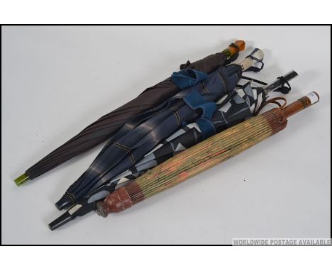 A collection of four vintage parasol / umbrellas, one being of Chinese origin along with three having lucite style handles pl