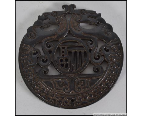 A detailed carved Chinese Jade bi depicting dragons.