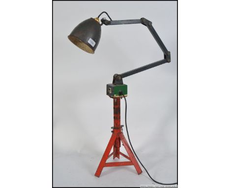An industrial MEMLITE work lamp top converted into a table lamp by means of having a car jack base attached , fully adjustabl