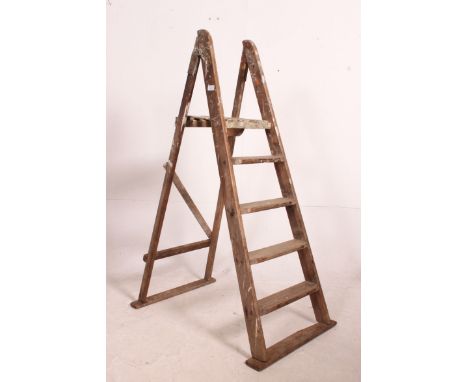 A vintage Industrial mid century wooden step ladder of medium proportion and a-frame construction.  Measures: 39cm x 18cm.