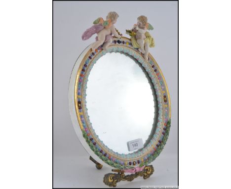A Meissen porcelain Barbola / dressing-table mirror frame, late 19th century, with central mirrored panel surmounted with a p