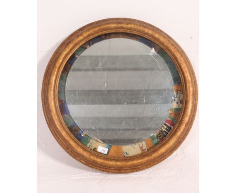 A 20th century up-cycled gilt framed wall mirror having an unusual mount to the mirror. Measures: 60cm diameter.
