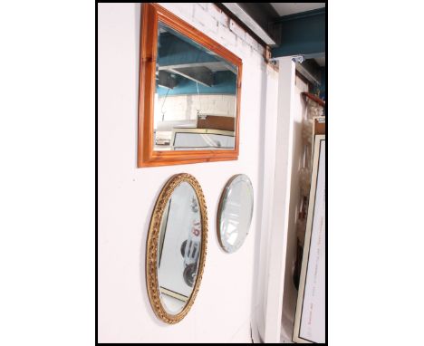 A bevelled edge art deco mirror along with a reproduction oak framed bevel edge mirror and a contemporary large pine framed m