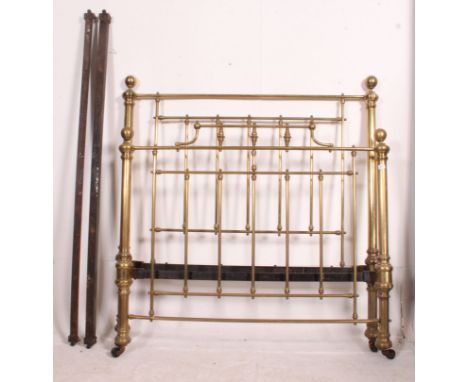 A Victorian large brass double bed complete with the runners. The bed with turned rail columns to head and footboard having f