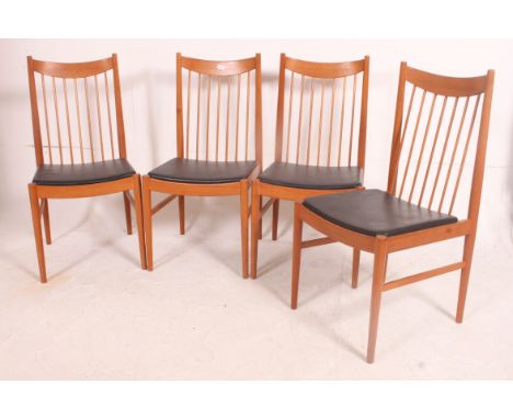 A stunning set of four retro vintage teak wood  high spindle backed  dining chairs with faux leather seat covers by SIBAST Of