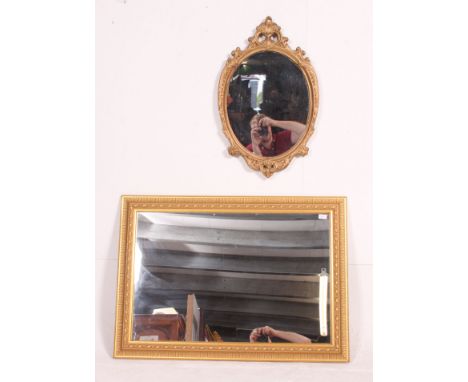 An ornate moulded gilt  framed early 20th century mirror along with another gilt rectangular mirror. Measures: 77cm x 107cm.