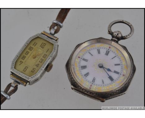 A continental silver 935 marked ladies open faced fob pocket watch with decorative gilded borders, roman numeral chapter ring