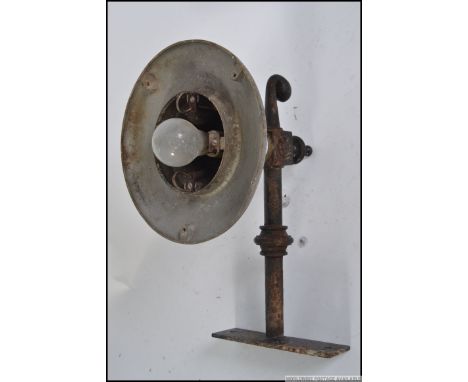 An Industrial 20th century dairy lamp - factory outside yard fitting with cast iron bracket with metal lamp top. Measures: 28