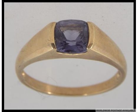 A hallmarked 9ct gold dress ring with large cushion cut amethyst in a rub over setting. Size S. Weight 3g.