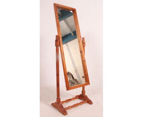 A 20th century pine cheval mirror raised on turned supports with splayed legs united by stretcher. Measures: 144cm x 49cm x 3