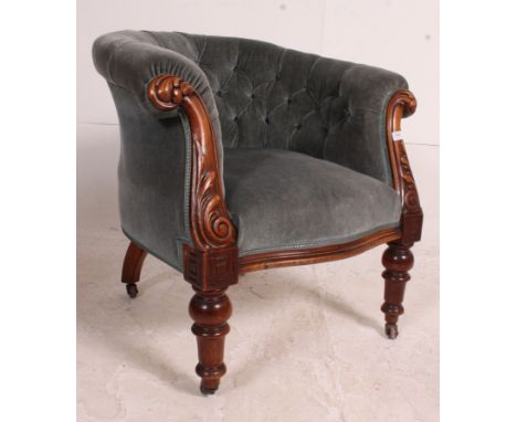 A good Victorian mahogany show wood chesterfield armchair raised on turned legs with ceramic castors having blue overstuffed 