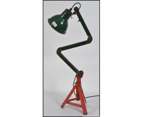 A retro industrial machinist lamp with racing green enamel shade , fully adjustable , on a heavy metal height adjustable trip