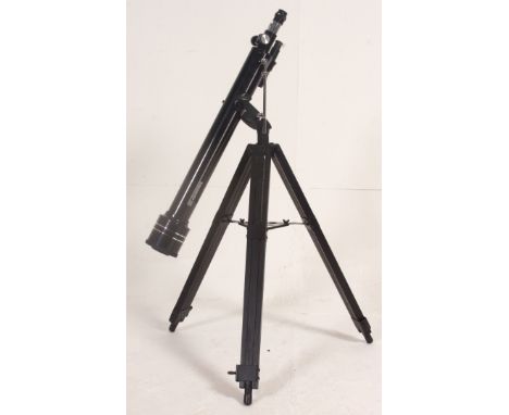 A 20th century Tasco Telescope and lens being raised on a wooden adjustable tripod base. Measures: 105cm x 66cm x 66cm.