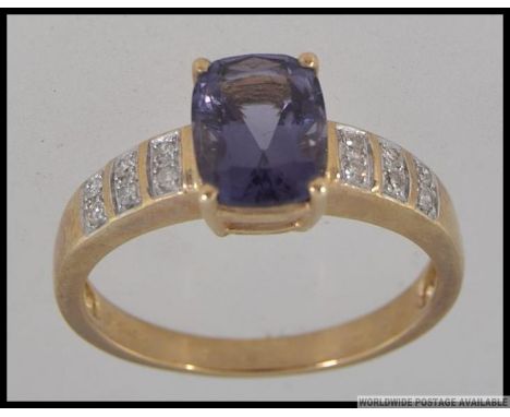 A hallmarked 9ct gold dress ring with large cushion cut Amethyst in a prong setting with diamond set accent shoulders. Size S