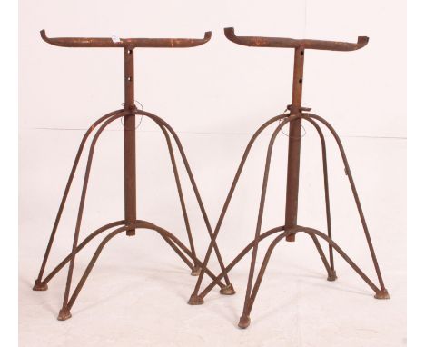A pair of vintage mid century Industrial adjustable cast metal trestles raised over hairpin style supports. Measures: 74cm x 
