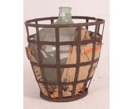 A vintage early 20th century glass acid carboy bottle complete in the original strap iron casket / basket surround. Measures: