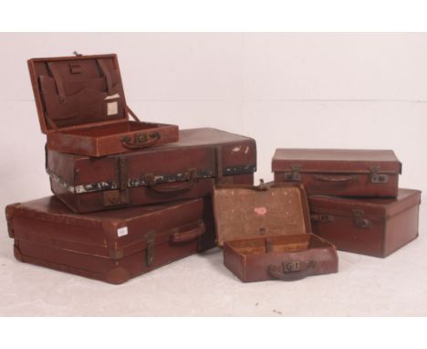 A stack of vintage suitcases to include varying sizes and styles all dating from the early 20th century