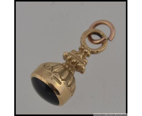 A hallmarked 9ct gold watch fob with scalloped decoration and round bale. Weight 3.9. Measures 2.5cms