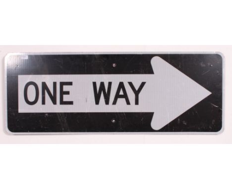 An Industrial 20th century  American ONE WAY road sign, having a black background with a reflective arrow with the words ONE 
