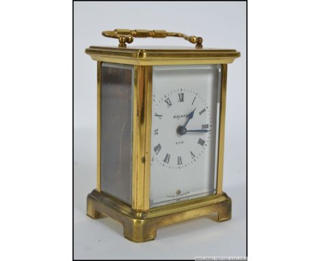 A brass carriage clock with an 8 day movement made by Bayard Of Paris. White face with Roman numerals. Measures: 15cm H.