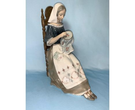 A Lladro figure of a seated girl with embroidery, 28cm (thumb a.f.) 