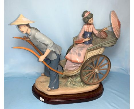 A Lladro group of a girl in rickshaw with parasol and young man, on plinth, 34cm 