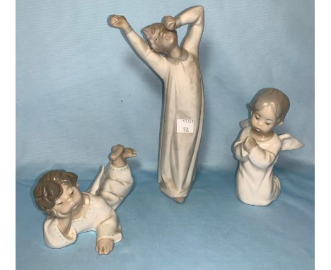 Two Lladro cherubs and a bisque figure of a boy yawning 