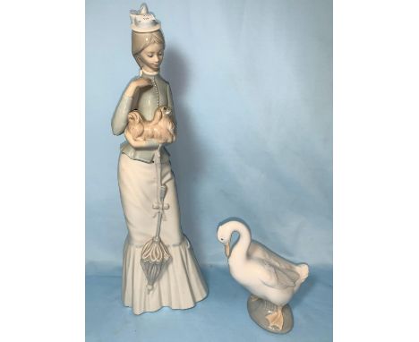 A Lladro girl in long dress holding a Pekinese and a Lladro goose 