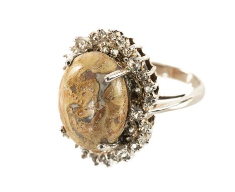 SILVER & FOSSIL DINOSAUR BONE RING, oval cabochon polished stone 15 x 11.5mm, within diamond-simulant halo, 5.4gProvenance: p