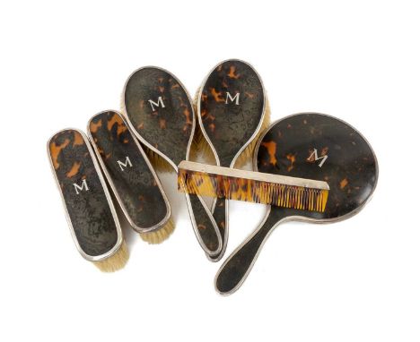 GEORGE V SILVER & TORTOISESHELL VANITY SET comprising mirror, four brushes and comb, baring the letter 'M', Birmingham 1928 (