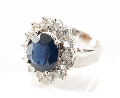 18K WHITE GOLD SAPPHIRE & DIAMOND CLUSTER RING, the central sapphire (10 x 9mms) within border of fourteen diamonds, stamped 