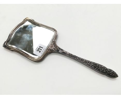 A Russian silver hand mirror with floral decoration to handle and engine turned reverse.