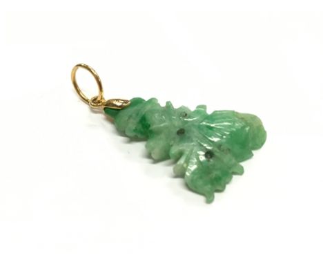 A jade pendant with a yellow metal fitting.