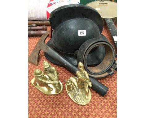 A fireman's helmet and belt together with an axe with rubber handle by Gilpin and two brass fireman ornaments.