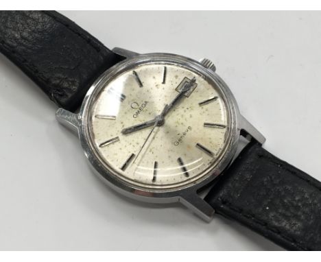 A gentlemans stainless steel Omega manual winding wrist watch with original Omega crown, tarnished silvered dial and date ape