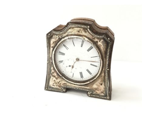 A miniature silver cased bedside clock.
(R8)