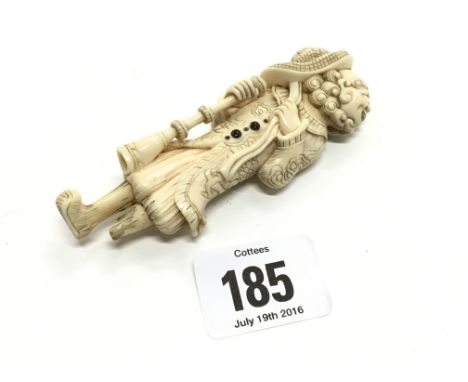 An 18th century ivory Netsuke with horn inlay modelled as a Dutchman.