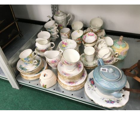 A shelf containing a large quantity of various china cups, saucers and teapots.