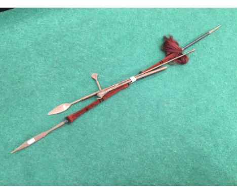 A Zulu axe with wooden handle and metal blade together with a Zulu Assegai spear with red fur bound shaft and straw bound cen