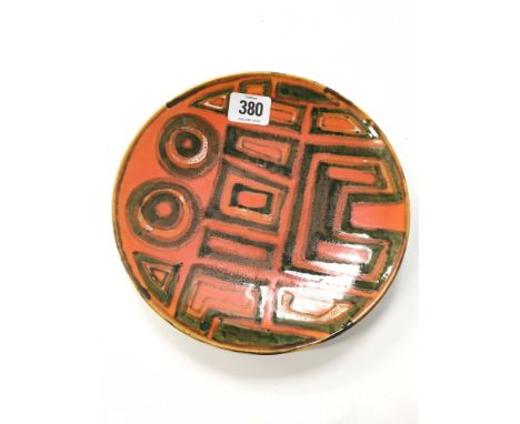 A Poole Pottery Studio dish in an Abstract design in early textured glazes (8 inches diameter).