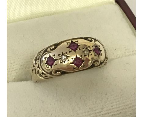 An antique 9ct gold diamond and ruby set gypsy style ring. Engraved pattern to top with 4 small rubies and 2 small diamonds. 