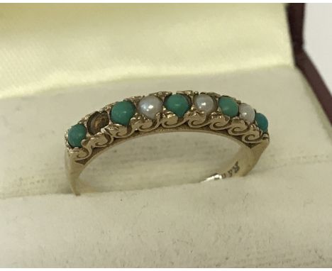 A 9ct gold turquoise &amp; seed pearl set half eternity ring. Scroll decoration to side of stone mount.One seed pearl missing