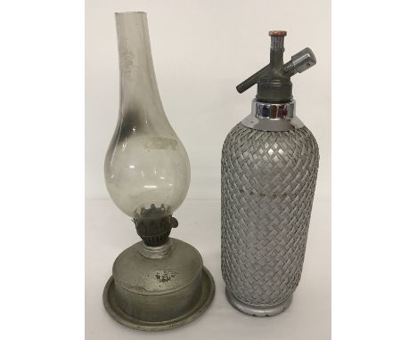 An Art Deco glass and wire mesh Sparklets soda syphon, together with a vintage oil lamp. Complete with glass chimney.