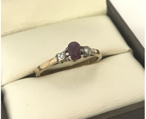 A vintage 9ct gold ruby and diamond dress ring. Central oval cut ruby with a small diamond to each shoulder. Ring size k½. To