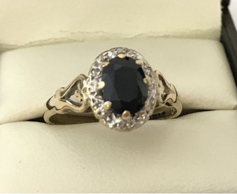 A vintage 9ct gold sapphire and diamond dress ring. Central oval cut sapphire approx. 1ct, surrounded by 6 illusion set small