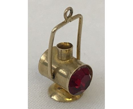 A 9ct gold lantern shaped charm, set with red coloured stone.