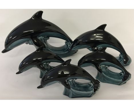 A collection of mid century Poole pottery dolphins with blue/green glaze. Comprising: 1 large, 1 medium and 3 small.
