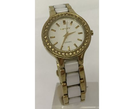 A ladies modern gold tone stainless steel and ceramic strap wristwatch by DKNY. Cream dace with gold tone hands and hour mark