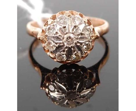 A yellow metal diamond set cluster ring, the illusion flower setting set with nine round cuts, stamped 585, 4.6g, size R