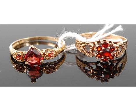 A yellow metal and heart shaped garnet set dress ring, stamped 9ct and 375, 1.4g; together with a 9ct gold garnet set cluster